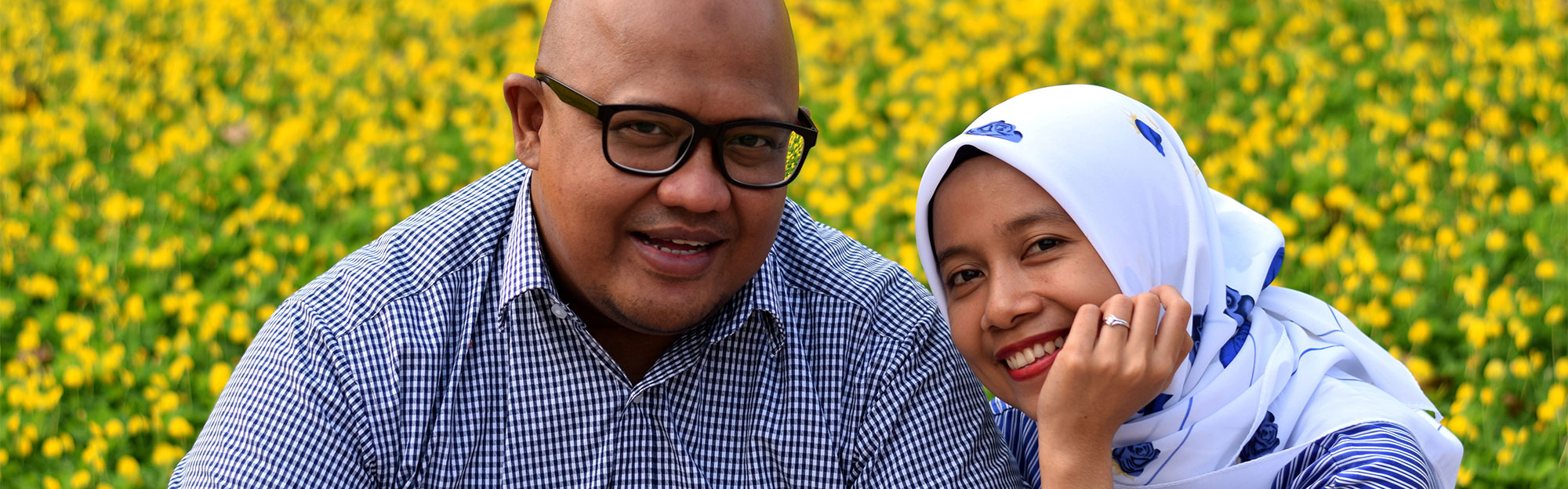 Man and Woman sitting in a field of yellow flowers