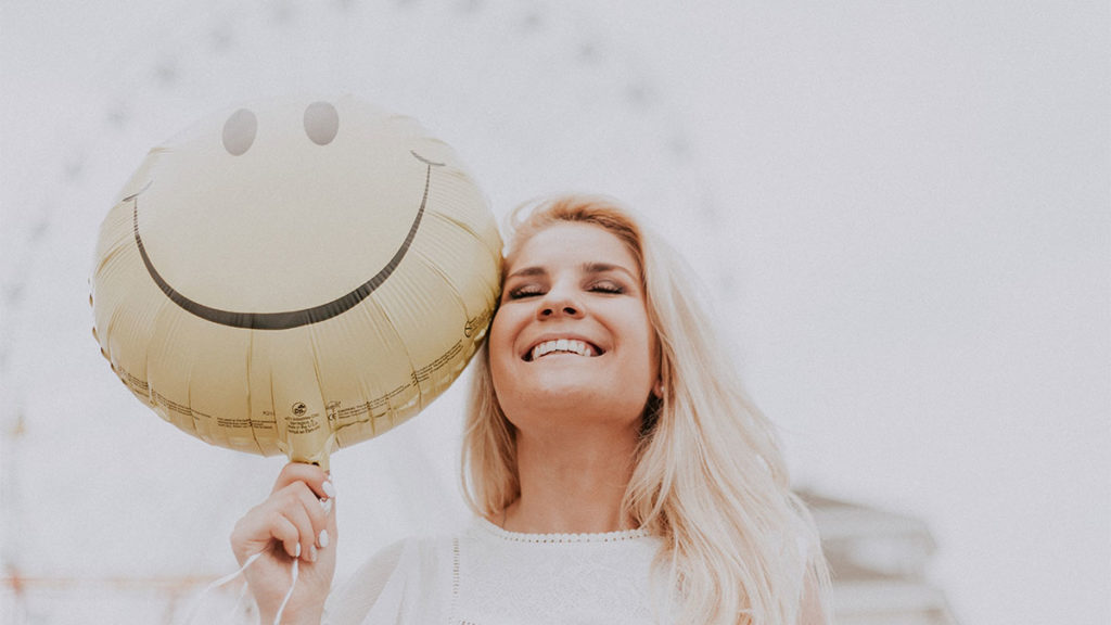 Customer Acquisition - Smiling woman with balloon
