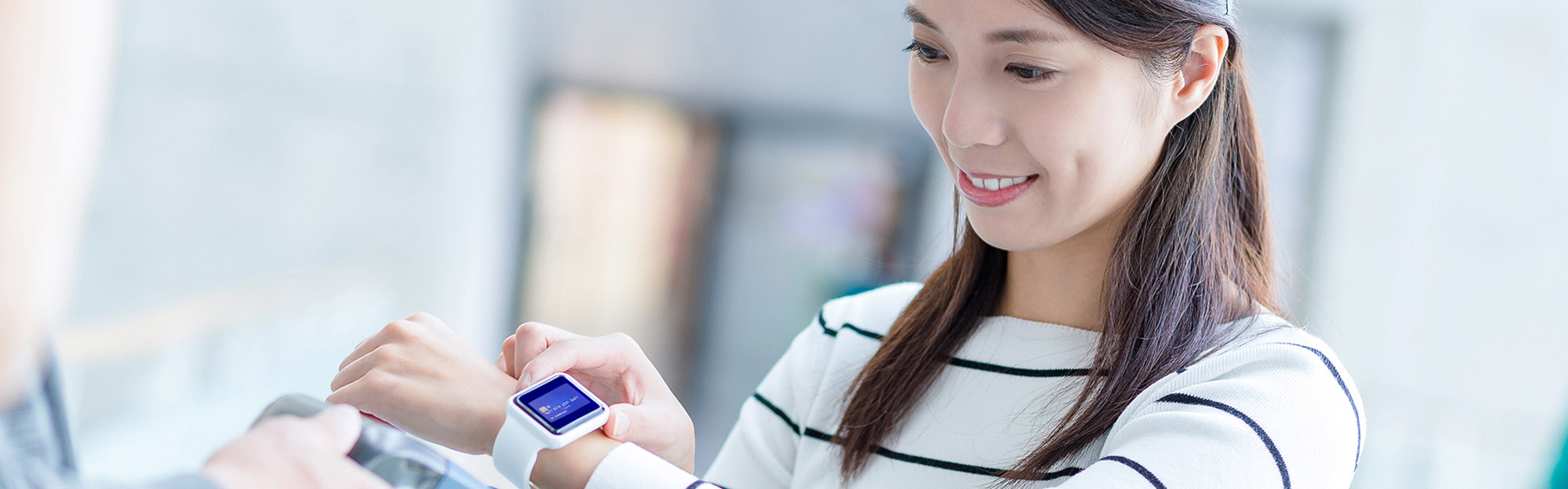 Temenos Payments - Woman using tap to pay