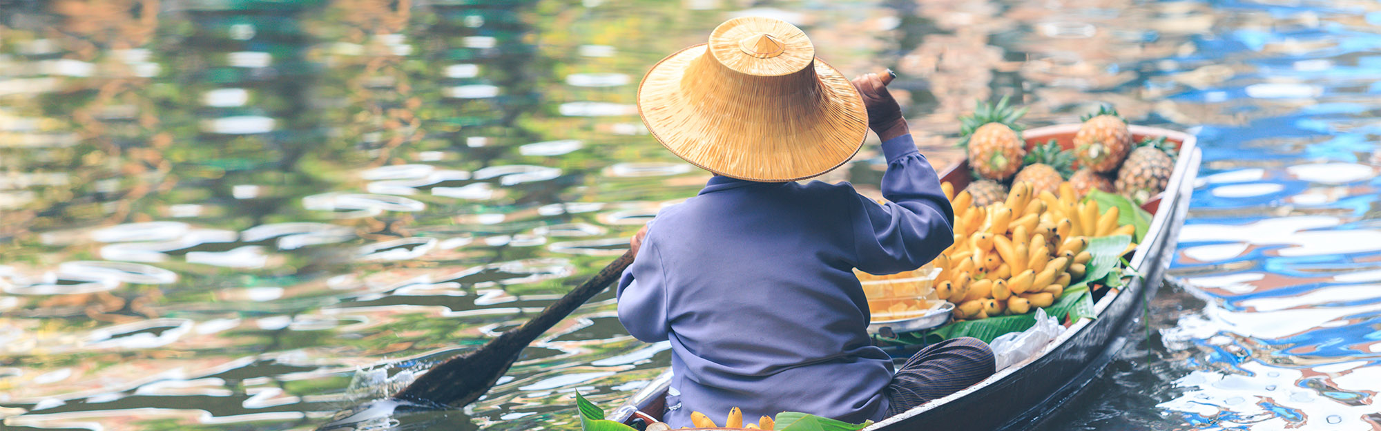 Woman in boat sells food at Thai floating Market. Bangkok.