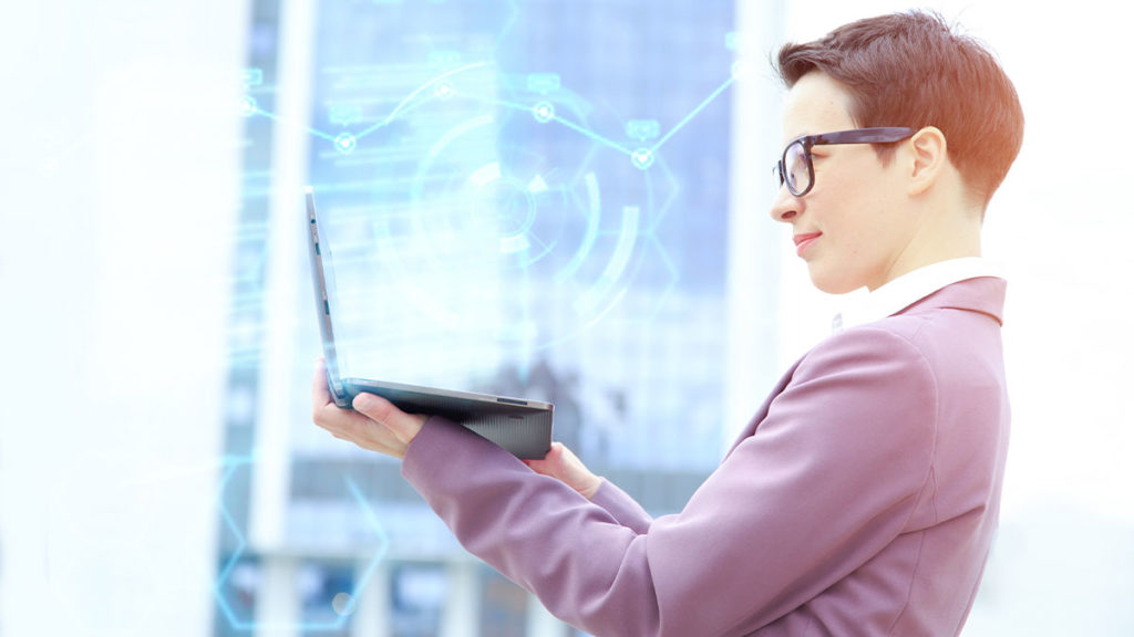 Microservices - Man in suit holding a laptop